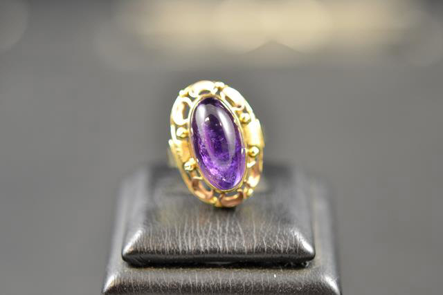 A 14k yellow gold German handmade ring set with oval cabochon cut amethyst, with rose gold