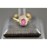 A 9ct gold ring with pink sapphire surrounded by diamonds in cluster setting - size N. CONDITION