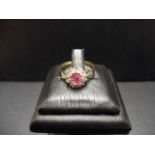 An 18ct gold ring with a pink sapphire surrounded by diamonds in a floral setting, size M - approx