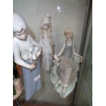 Lladro figure of a recumbent girl with dove, unglazed girl with staff and a similar Spanish figure