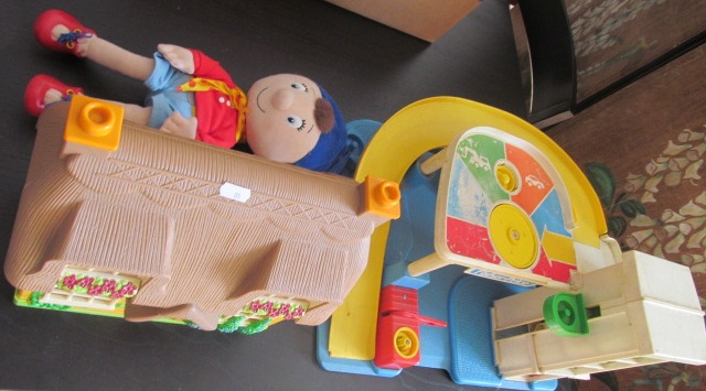 A Fisher Price toy garage, a small dolls house and a Noddy toy