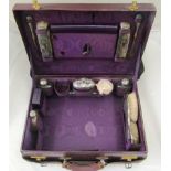 An early 20th century purple leather ladies vanity case fitted with silver dressing table jars,