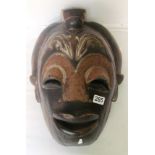 A large wooden mask inlaid copper and brass