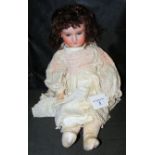 An old Armand Marseille bisque head doll with rolling eyes and open mouth, having composite body,