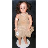 An old German bisque head doll with glass eyes, open mouth and pierced ears, having composite body -