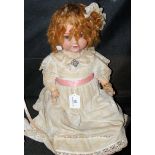 An old Armand Marseille bisque head doll with rolling glass eyes and open mouth, having composite