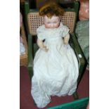 An old German bisque head doll with composite body, in original clothing, for restoration in a