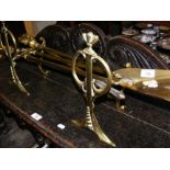 An Art Nouveau style pair of brass fire dogs with tools