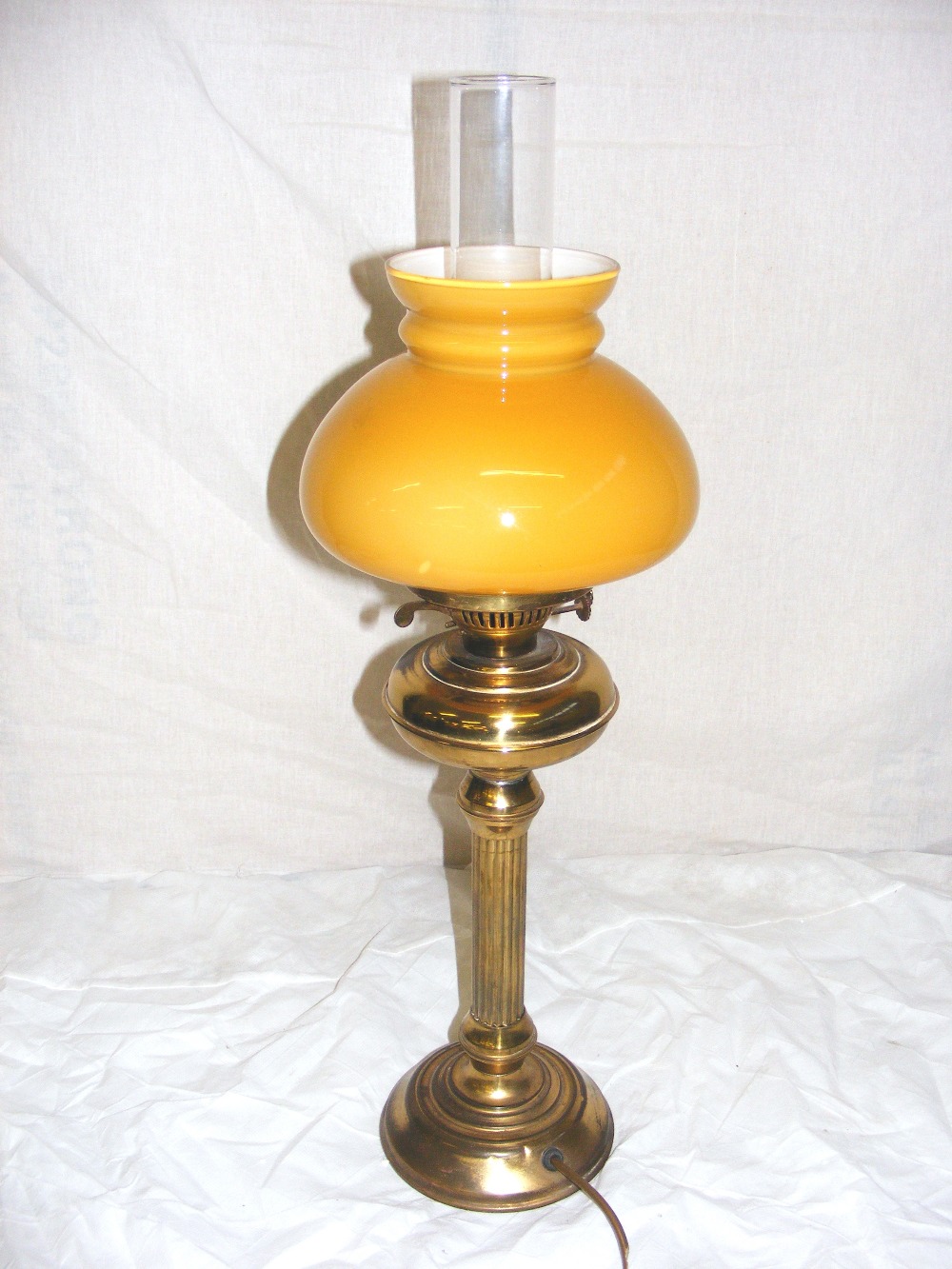 A brass oil lamp, with a chimney & yello