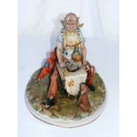 A Capodimonte figurine of a seated man.