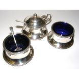 A three piece sterling silver cruet set hallmarked for Birmingham, with original cobalt glass liners