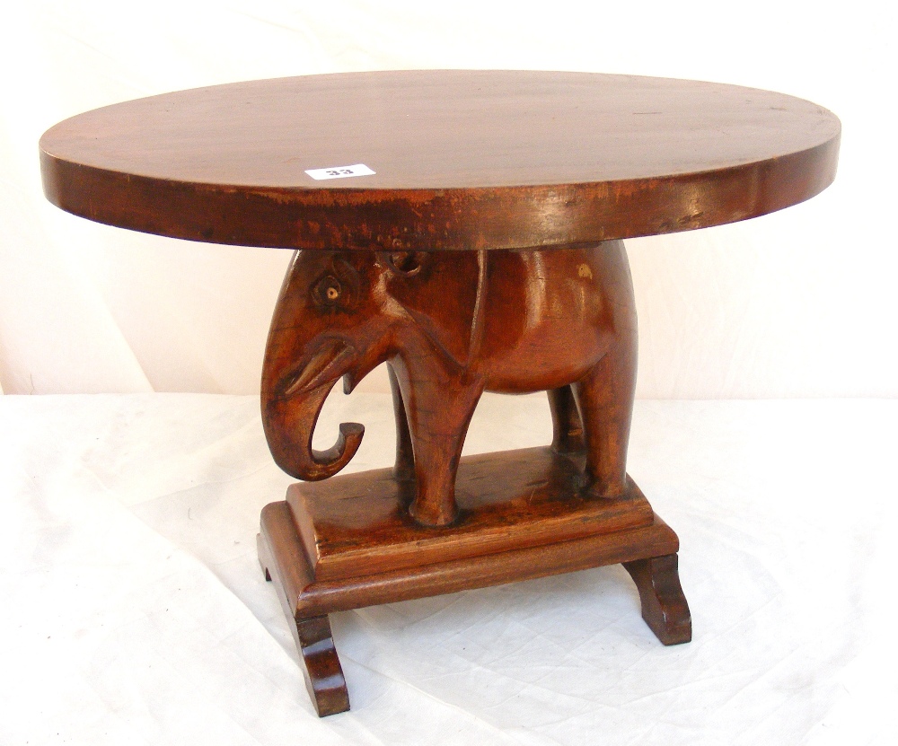 A hardwood table with central elephant c