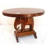 A hardwood table with central elephant c