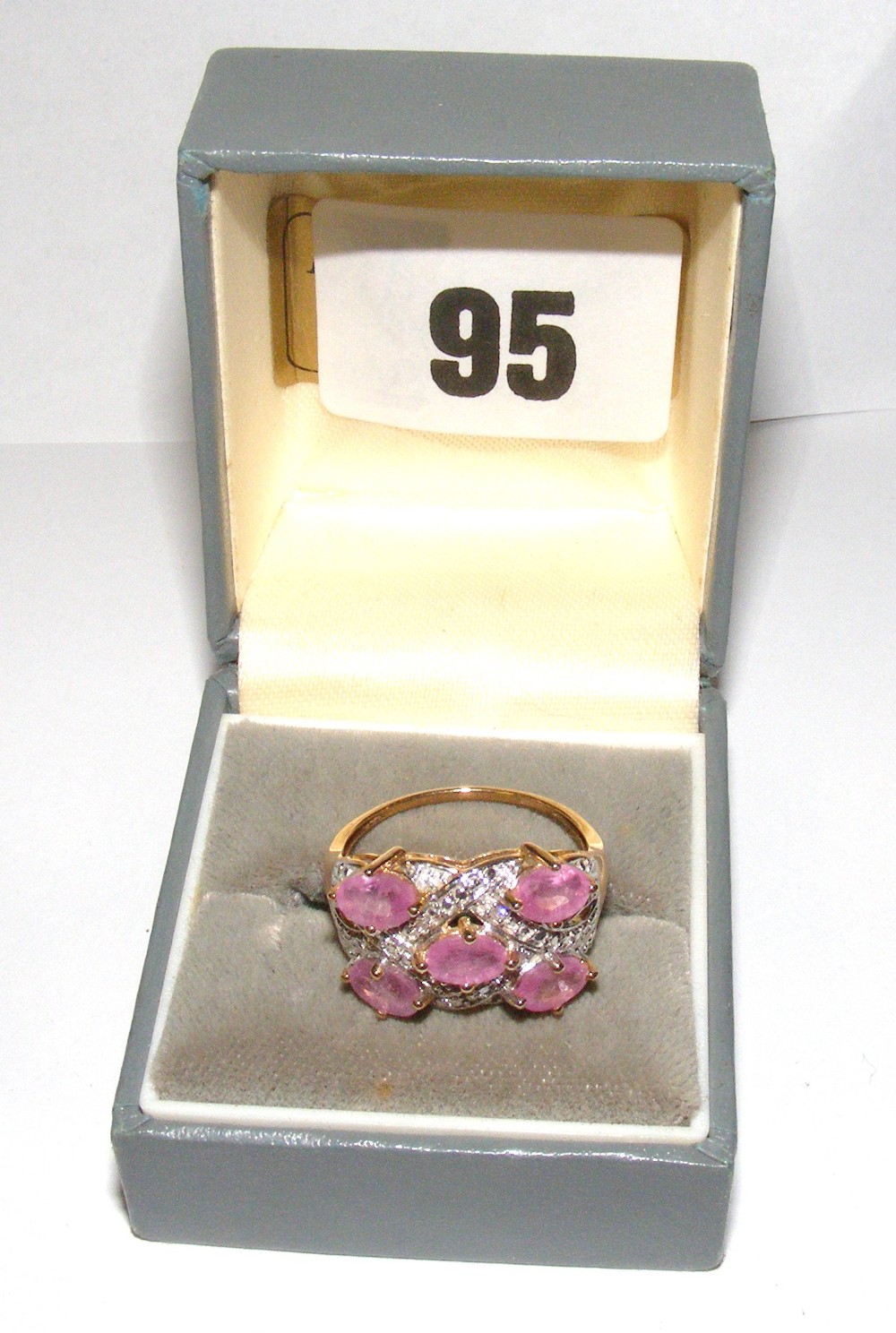 A gold ring set with pink sapphires & di