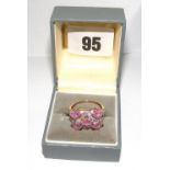 A gold ring set with pink sapphires & di