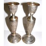 A pair of solid eastern silver candlesti