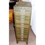 A vintage industrial filing cabinet standing on four legs. CONDITION REPORT: Lacking its key.