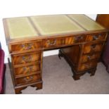 A writing desk with green tooled leather top. CONDITION REPORT: Note: we do not offer an in house