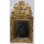 Miroir style Rocaille en bois doré, surmonté de coquilles fleurs et rinceaux, 47 x H. 87 cm  (