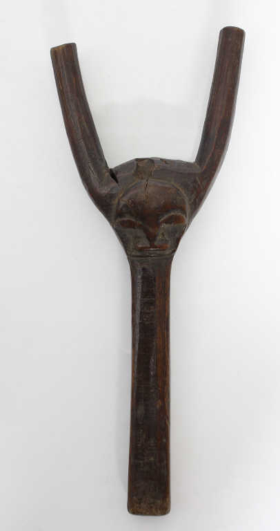 Baoulé (Côte-d'Ivoire) - Petit lance-pierres sculpté d'un visage stylisé. Bois à patine d'usage.