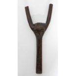 Baoulé (Côte-d'Ivoire) - Petit lance-pierres sculpté d'un visage stylisé. Bois à patine d'usage.