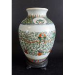 An Early Chinese Oviform Vase with a foliate design upon a white ground and hardwood stand,