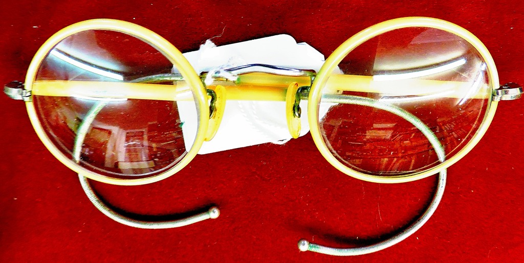 1950's round cream-coloured plastic covered steel framed, cable armed spectacles. Fair condition.