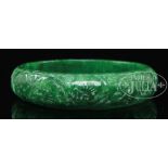 SPINACH GREEN JADEITE BANGLE. Carved with longevity fungus on the exterior. SIZE: 2-3/4” dia