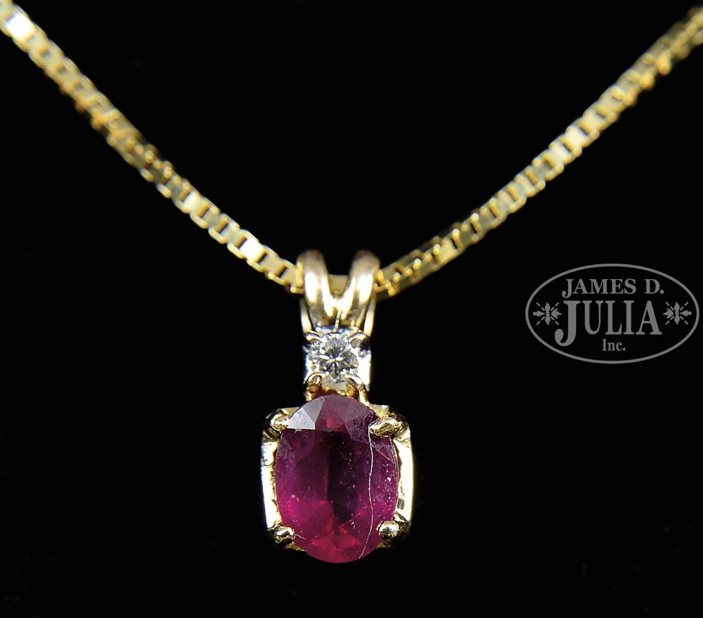 RUBY AND DIAMOND PENDANT ON A 14KT YELLOW GOLD NECKLACE. The pendant having an oval ruby of
