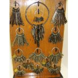 KEYS, wooden rack display of 14 bunches of assorted steel and metal keys including several early