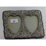 A silver plated plated twin photo frame with ornate scrolling repousse deco.