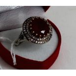 A silver CZ and large central ruby ring