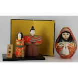 Japanese round doll with fabric covering and a Japanese ceramic man & wife on stand