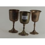 A pair of silvered metal goblets and another similar