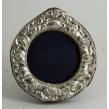 A silver embossed round picture frame on easel back