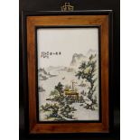 A CHINESE FRAMED PORCELAIN PLAQUE, decorated with calligraphy and a river landscape scene, the frame