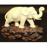 A FINE QUALITY SIGNED JAPANESE MEIJI PERIOD TOKYO SCHOOL IVORY MODEL OF AN ELEPHANT, together with a