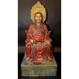 A LARGE CHINESE GLAZED STONEWARE MODEL OF A DEITY, seated upon a throne and supported by a raised
