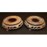 A PAIR OF EARLY 20TH CENTURY CHINESE CARVED HARDWOOD VASE STANDS, each carved and pierced to the