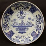 AN EARLY 18TH CENTURY CHINESE BLUE & WHITE PORCELAIN DISH, painted to its centre with a basket of