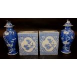 A PAIR OF 19TH CENTURY CHINESE BLUE & WHITE PORCELAIN PRUNUS VASES & COVERS, each base with a four-