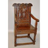 A 17TH CENTURY STYLE CARVED OAK WAINSCOT CHAIR.