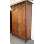 AN 18TH CENTURY FRENCH OAK ARMOIRE, with moulded cornice above a pair of doors with carved