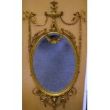 A VERY GOOD ADAM DESIGN OVAL GILT MIRROR with urn finial, ribbon motifs and garlands.Overall Size: