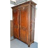 AN 18TH CENTURY FRENCH OAK ARMOIRE, with moulded cornice above a pair of doors with carved