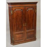 A 19TH CENTURY OAK HANGING CORNER CUPBOARD, dentil moulded cornice over a pair of panelled doors,
