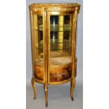 A FRENCH GILT WOOD VITRINE of serpentine outline, the single glazed door enclosing two glass shelves