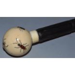 AN EBONY CANE with ivory ball handle, shibyama decorated with insects.  33ins long.