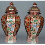 A GOOD PAIR OF JAPANESE OCTAGONAL SHAPED VASES AND COVERS, all over decoration of birds and flowers.