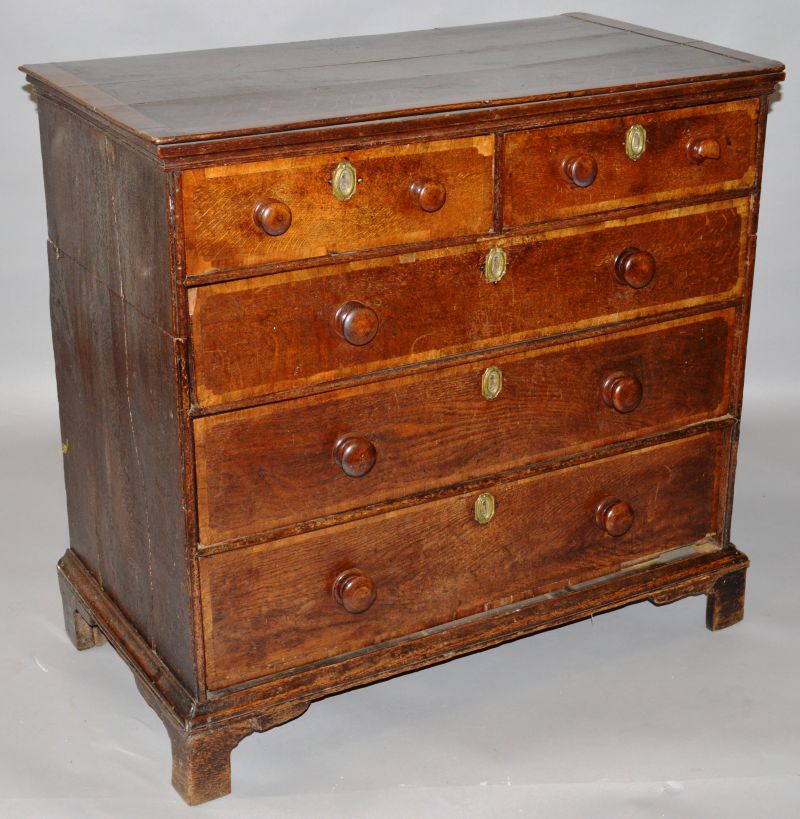 AN 18TH CENTURY OAK AND MAHOGANY CROSSBANDED STRAIGHT FRONT CHEST of two short and three long,